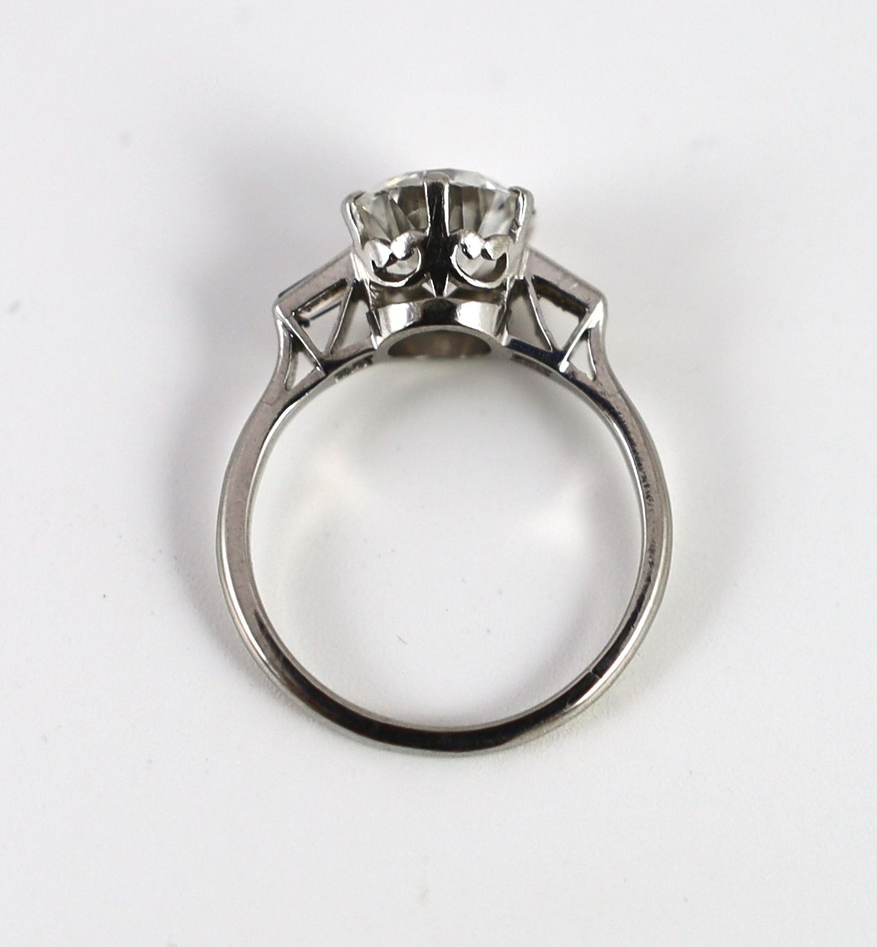 A mid 20th century platinum and single stone diamond ring, with trapeze cut diamond set shoulders